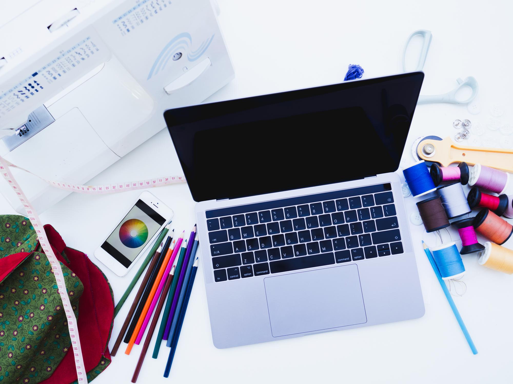 Tavolo da lavoro con campioni ricamo e laptop